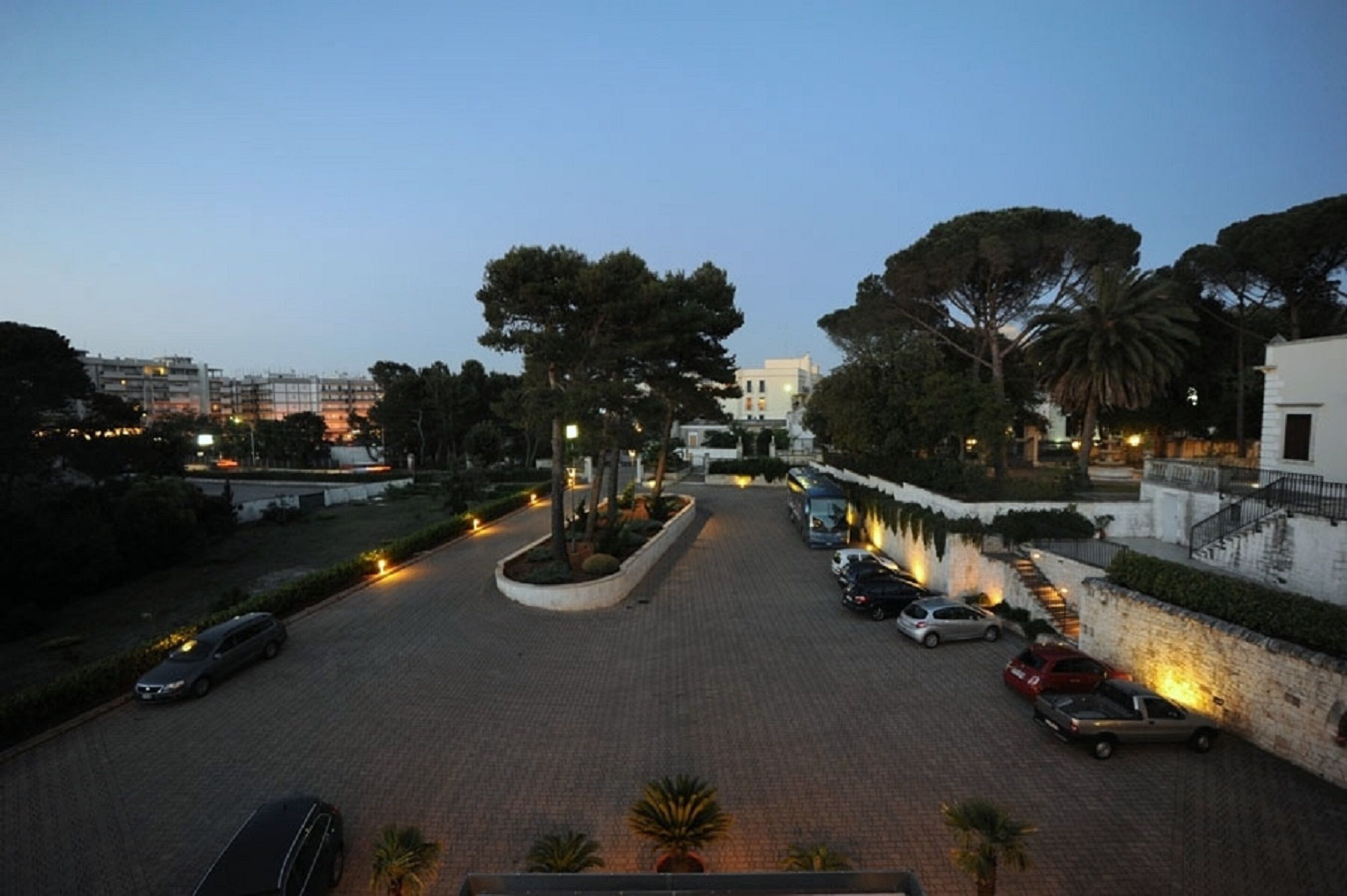 A parking area with cars and a pathway leading to a building.