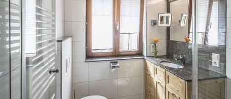 Ein modernes Badezimmer mit Toilette, Waschbecken und Waschtisch.