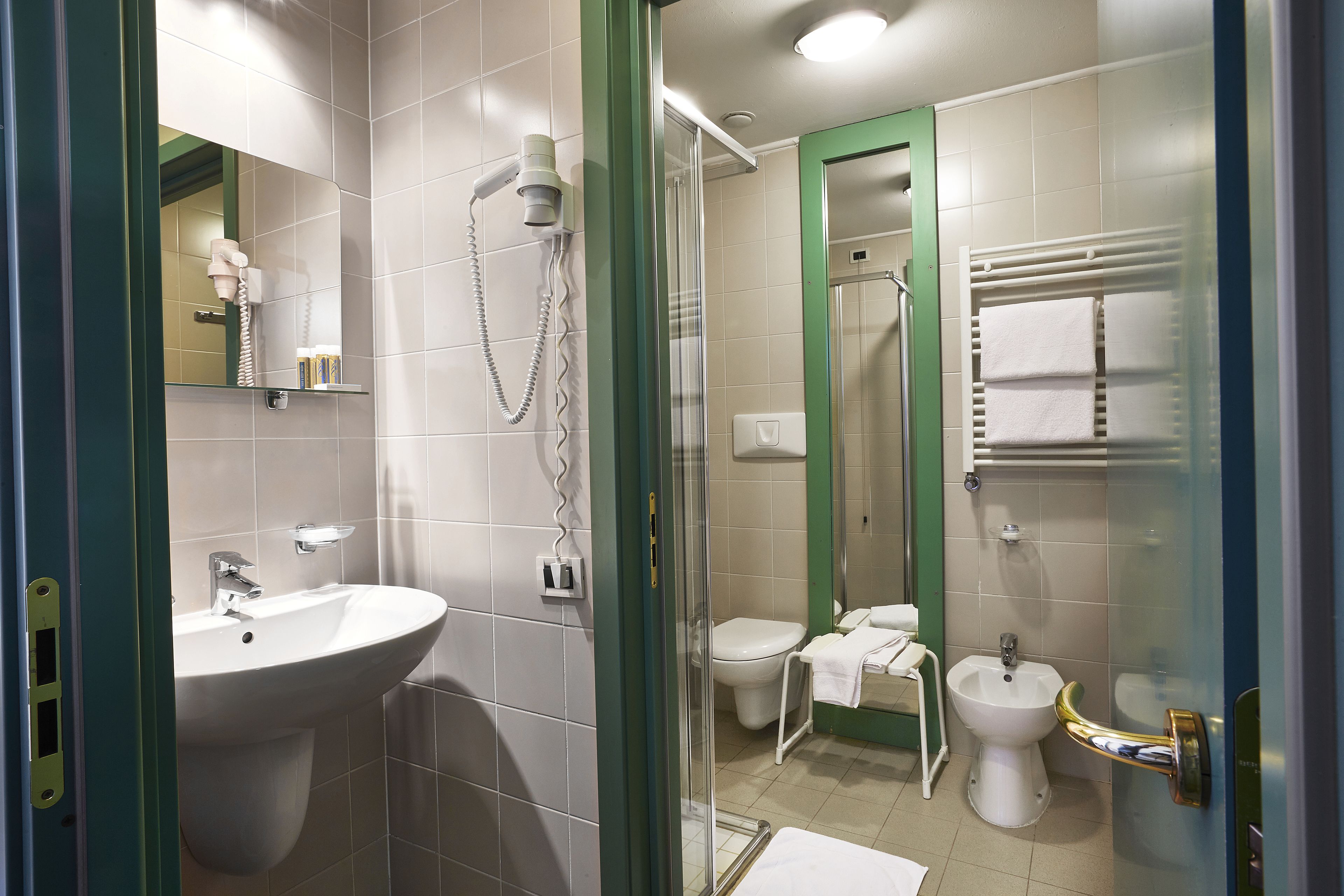 A modern bathroom with a glass-enclosed shower, a sink, and a bidet.