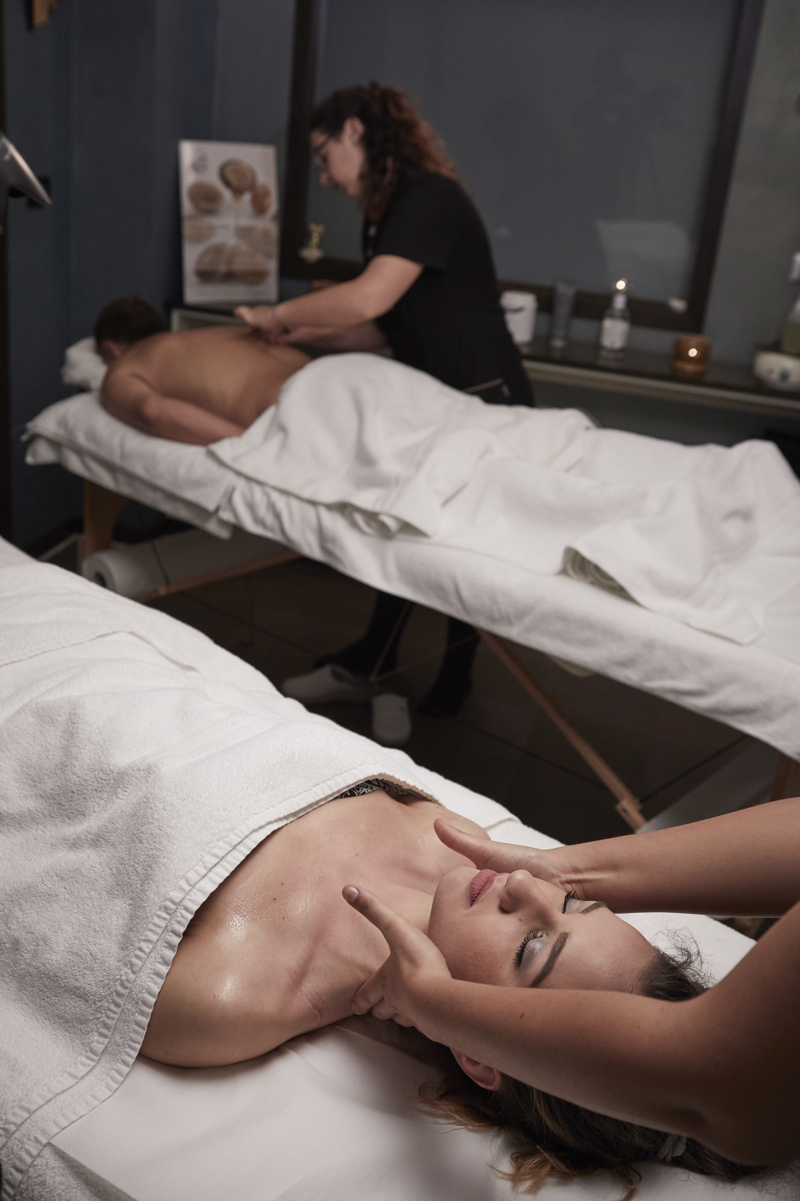 Una stanza per massaggi con due clienti che ricevono trattamenti.