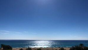 Une plage avec un ciel dégagé et une mer calme.