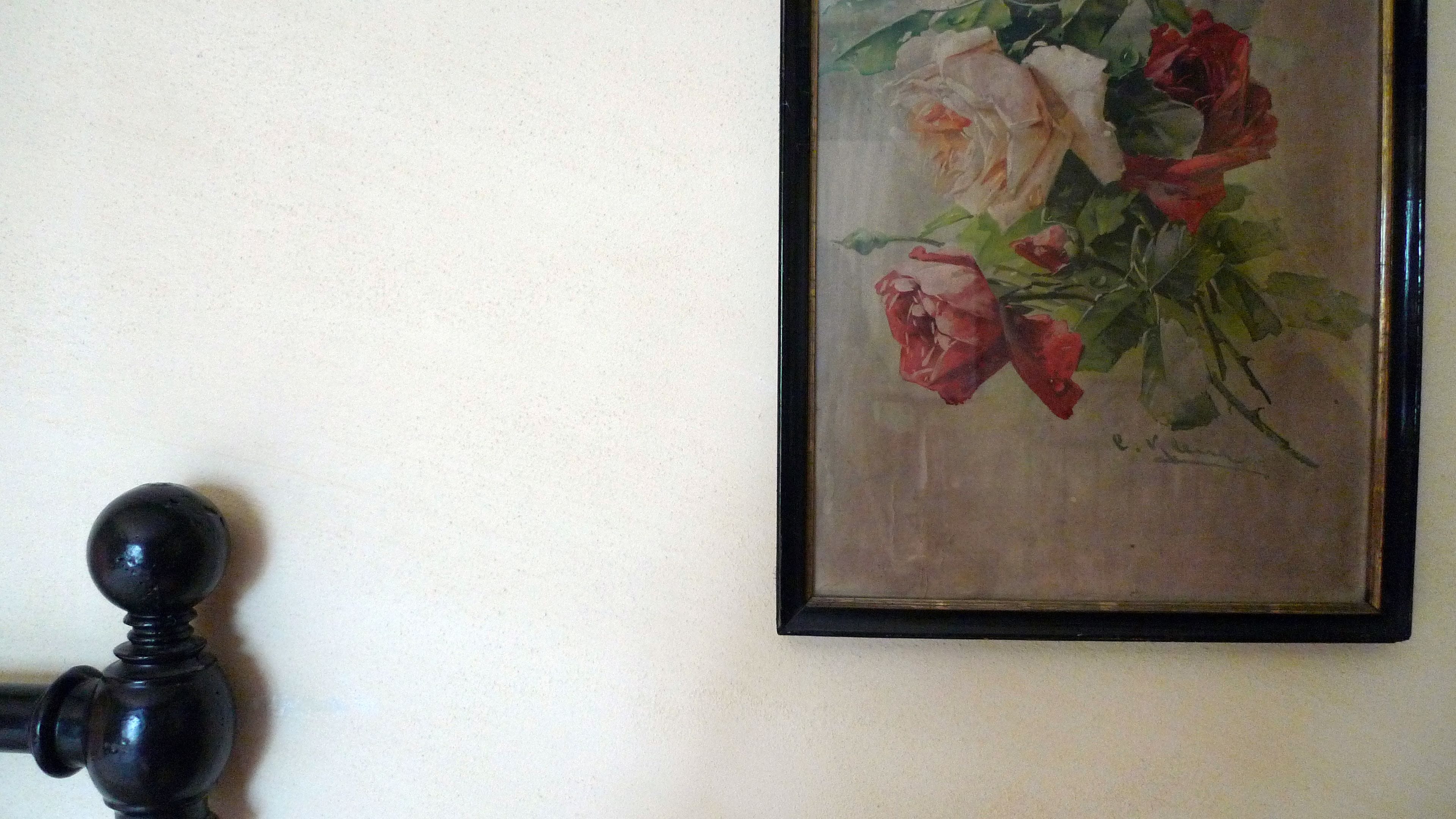 Un quadro floreale incorniciato appeso al muro.