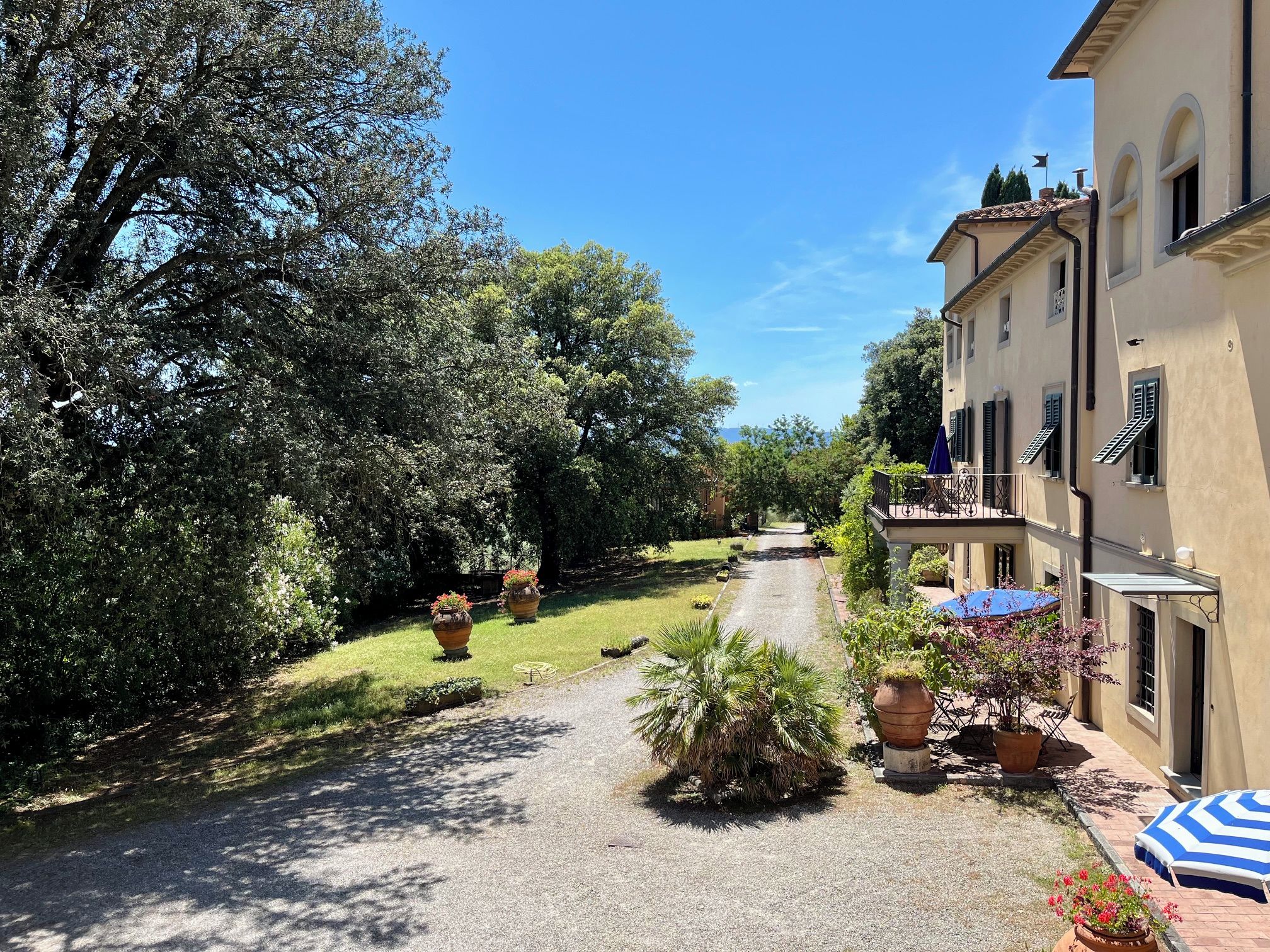 Ein Weg zu einem Gebäude mit Garten und Sitzbereich im Freien.