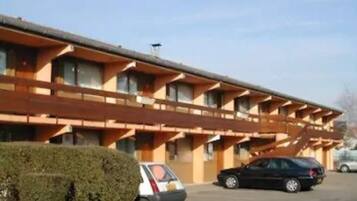 A multi-story motel with a flat roof and a row of windows on each floor.