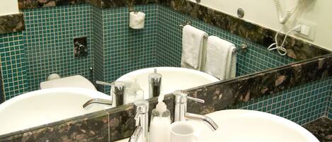 A bathroom with two sinks, a mirror, and a towel rack.