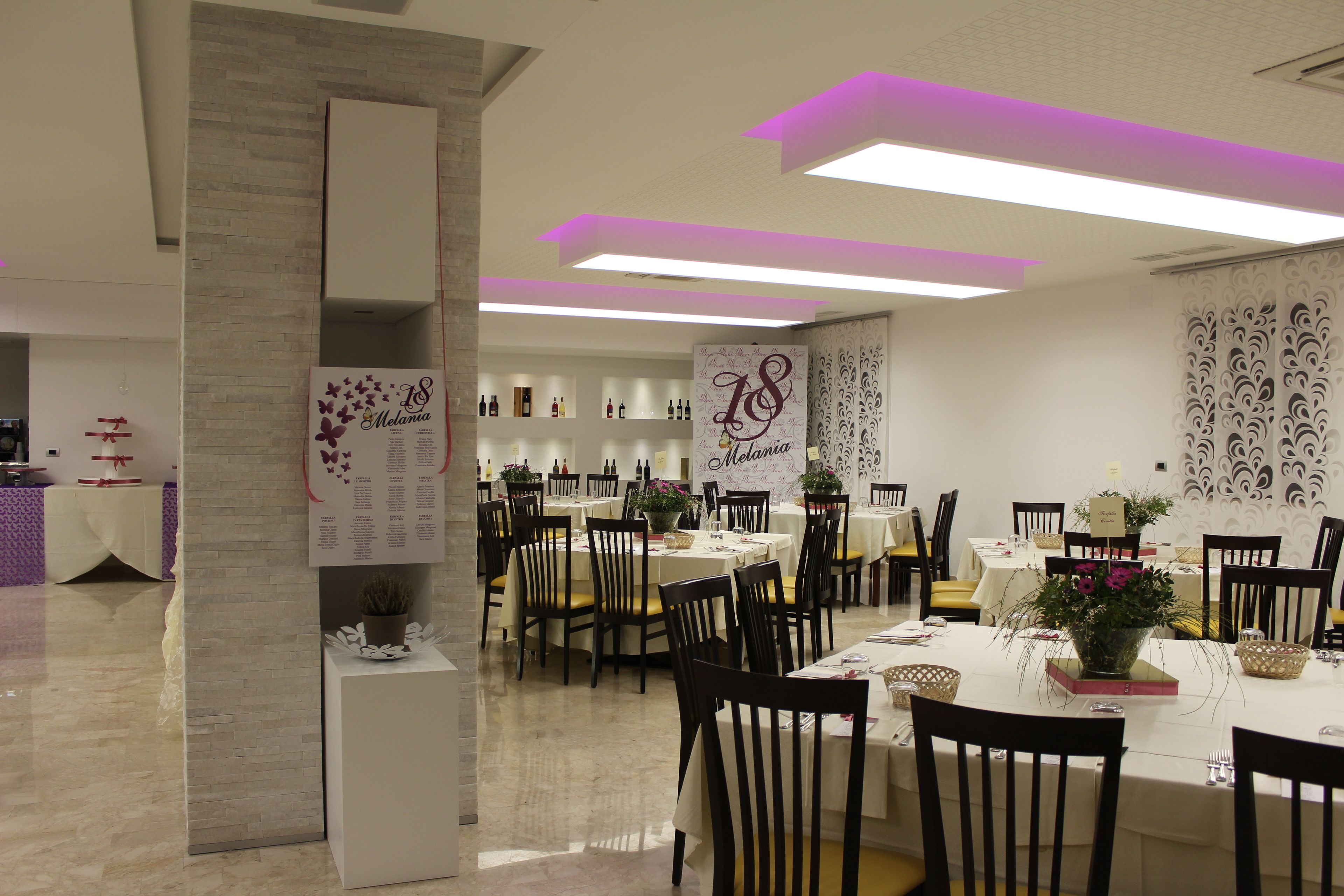 A restaurant with multiple tables and chairs, a menu board, and decorative wall panels.