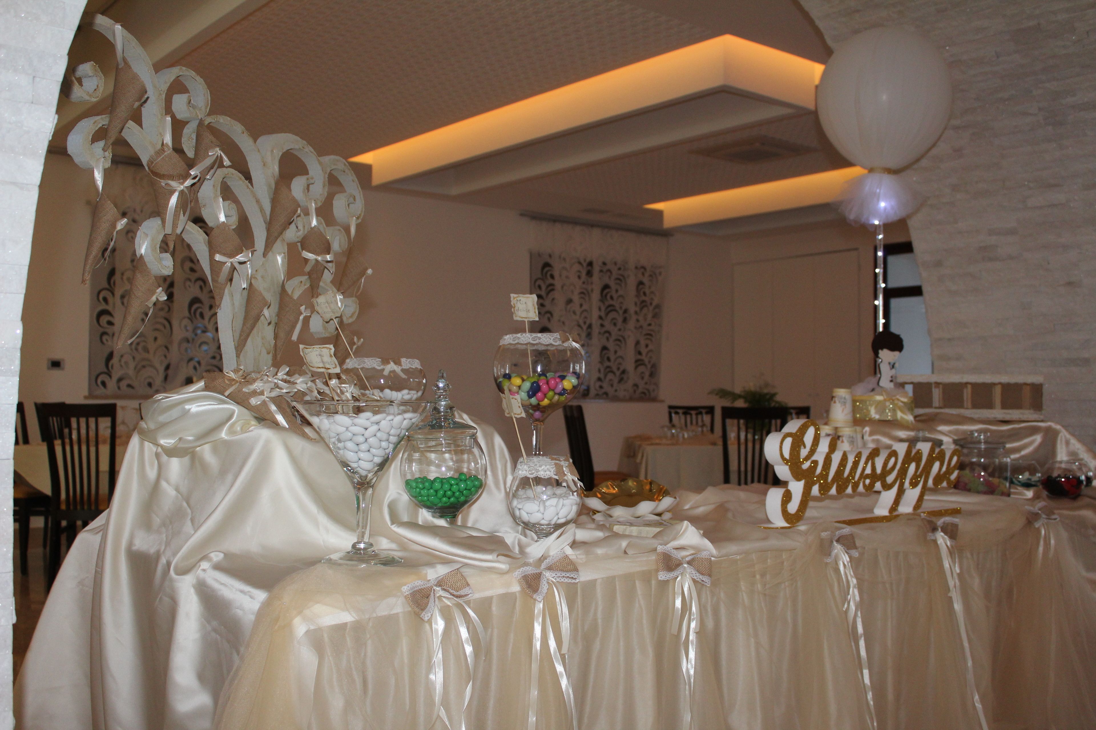 A table set with a name card, decorative glassware, and various food items, suggesting a formal event or celebration.
