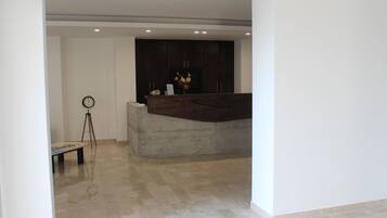 Ein modernes Interieur mit einer Betonbank, einem Stativ und einer Uhr an der Wand.