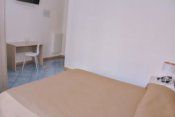 A room with a bed, a desk, and a chair. - Hotel Piccolo Sogno (Pompei)