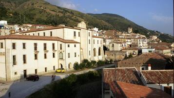 Une ville dotée de bâtiments historiques, d’une route et d’un paysage vallonné en arrière-plan.