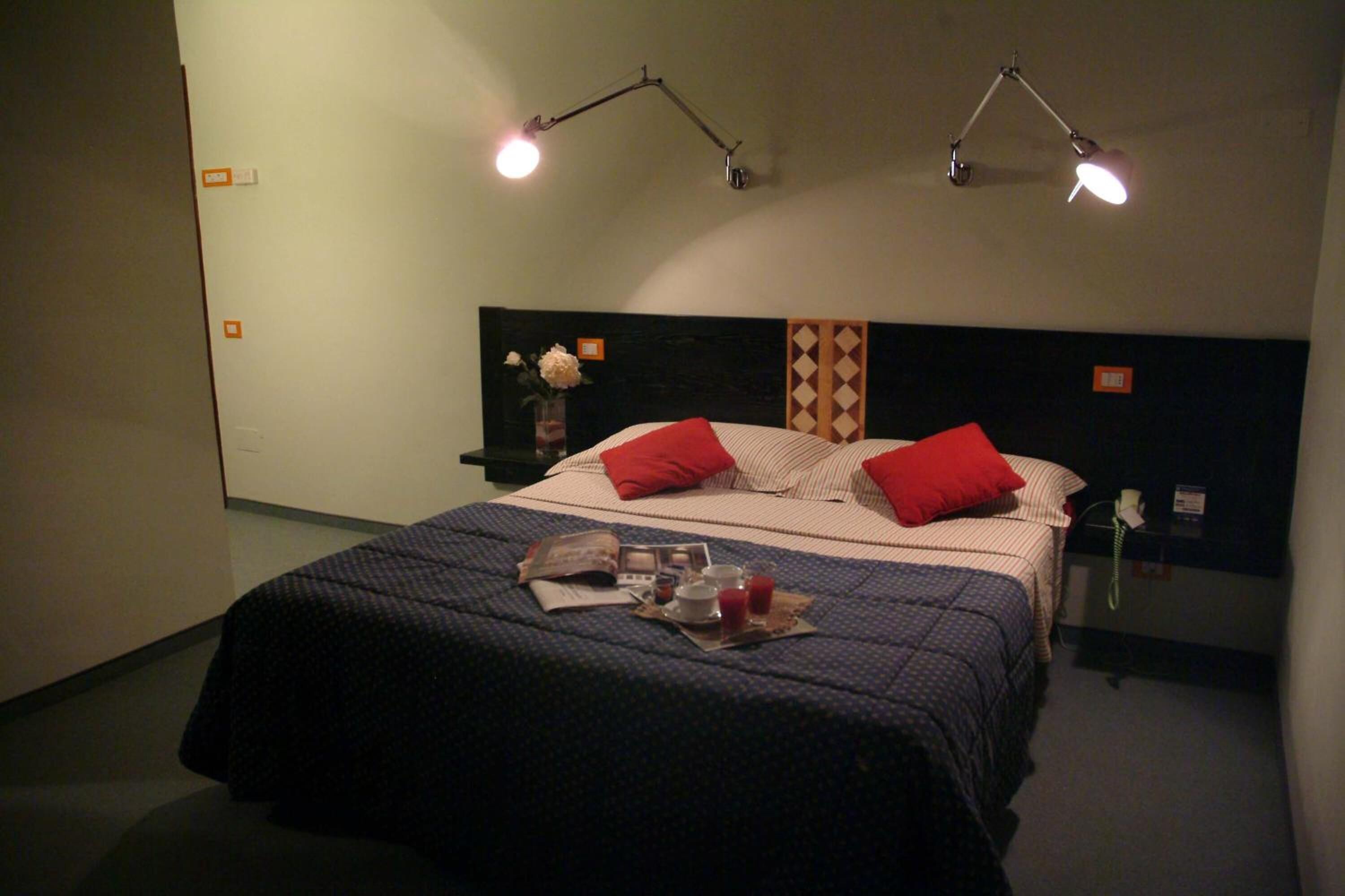 Une chambre d’hôtel avec un lit, deux lampes de chevet, une table de chevet et un téléphone.