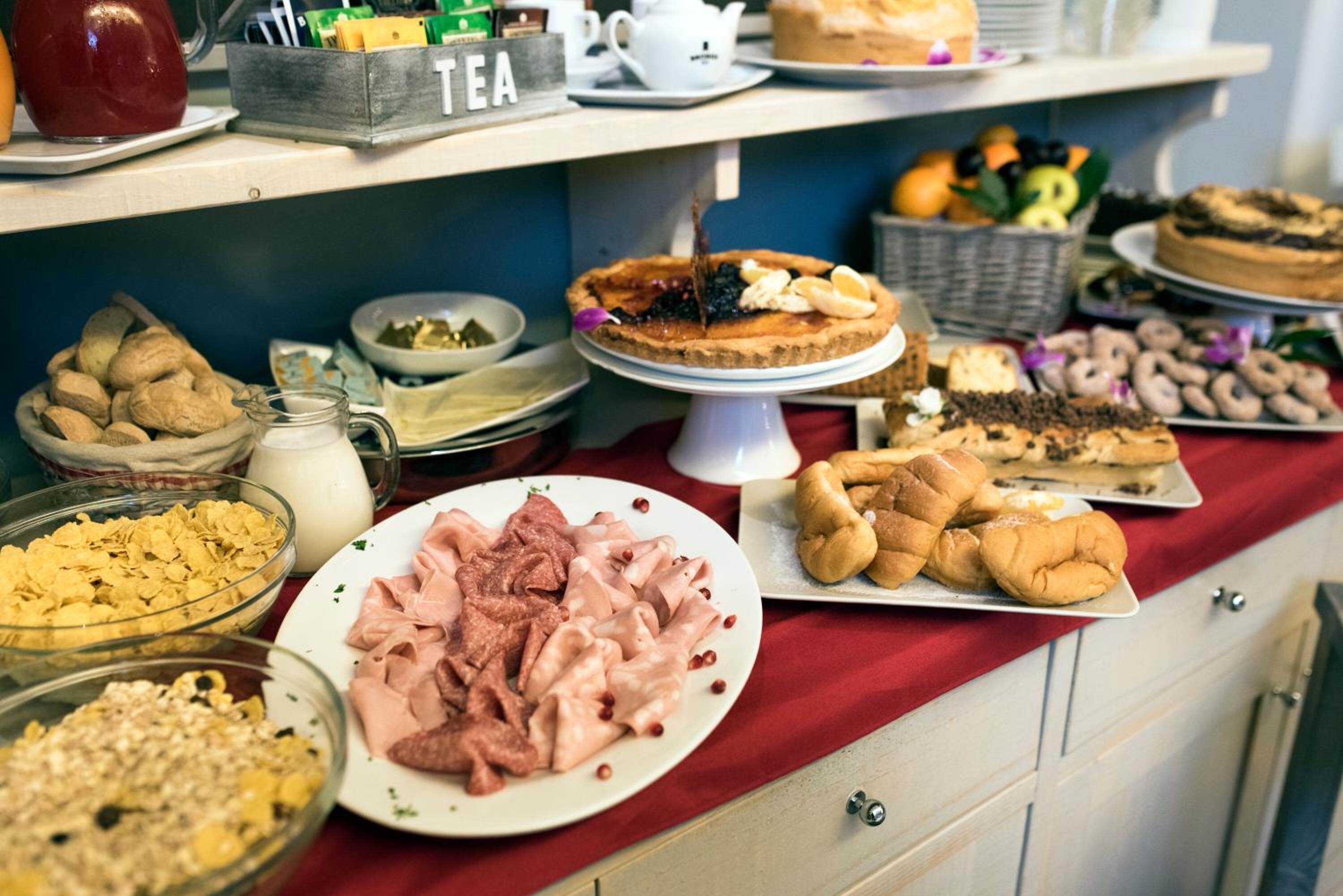 Una mesa de buffet con diversos alimentos, como pasteles, carnes y postres.
