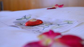 A bed with a decorative heart and a floral pattern.
