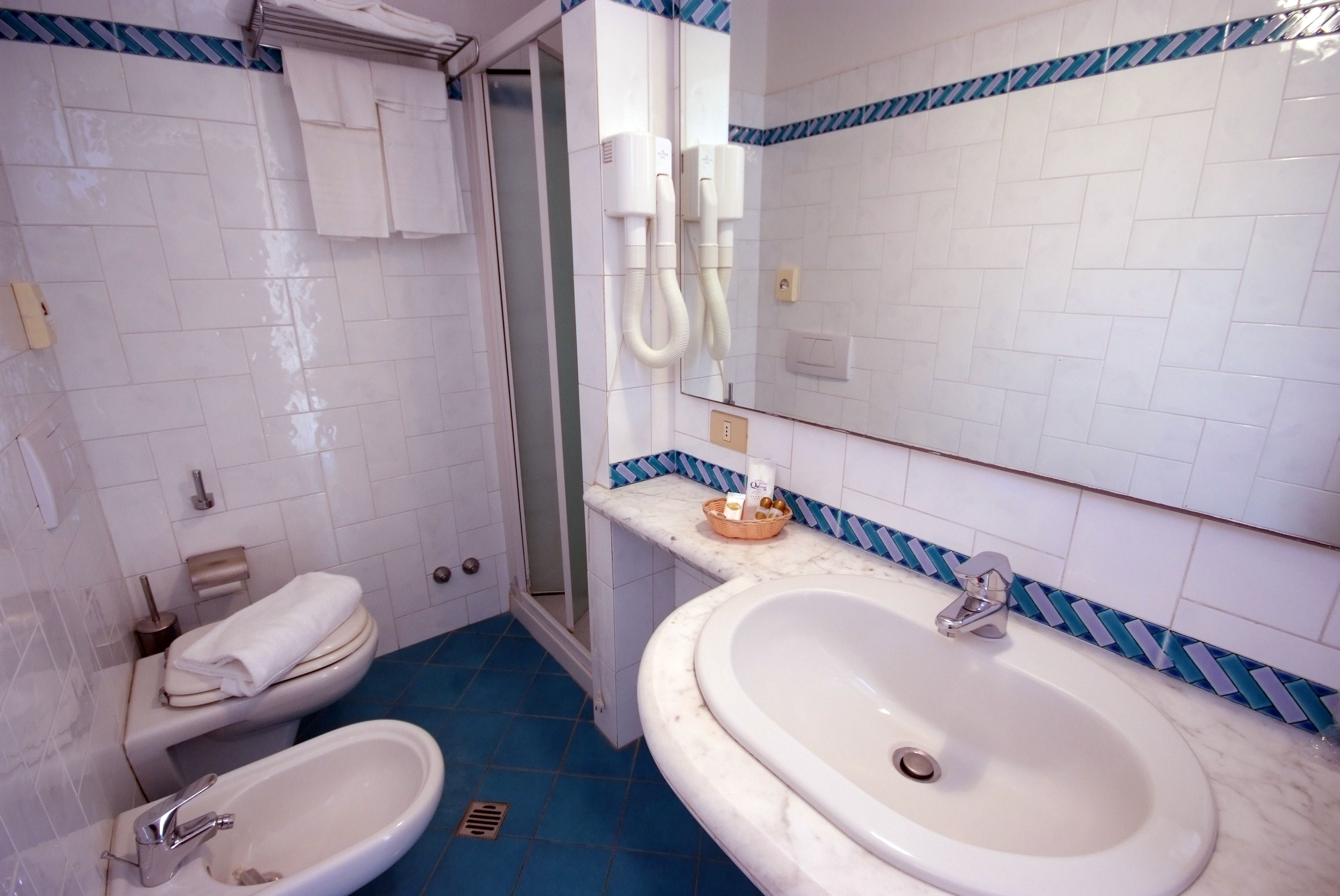 Un bagno con due lavandini, un water e una doccia.