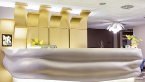 Una recepción con diseño moderno, suelo de baldosas e iluminación empotrada en el techo.