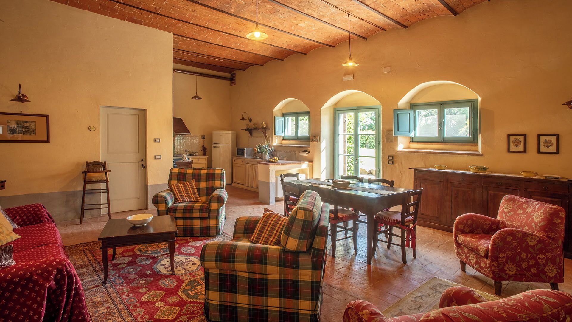 Una sala de estar acogedora con chimenea, un comedor con mesa y sillas, y una cocina con isla.