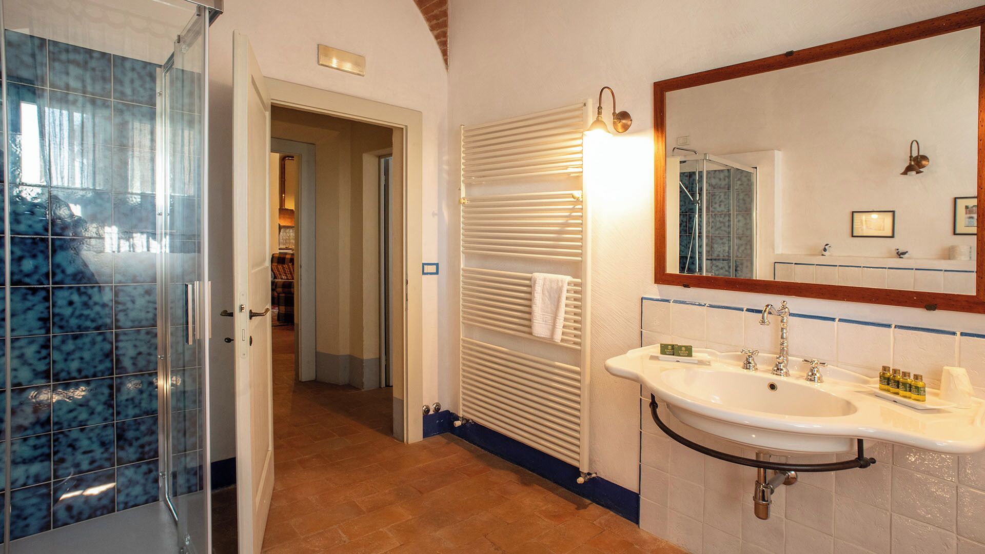 Une salle de bain avec un lavabo blanc, un miroir et un porte-serviettes.