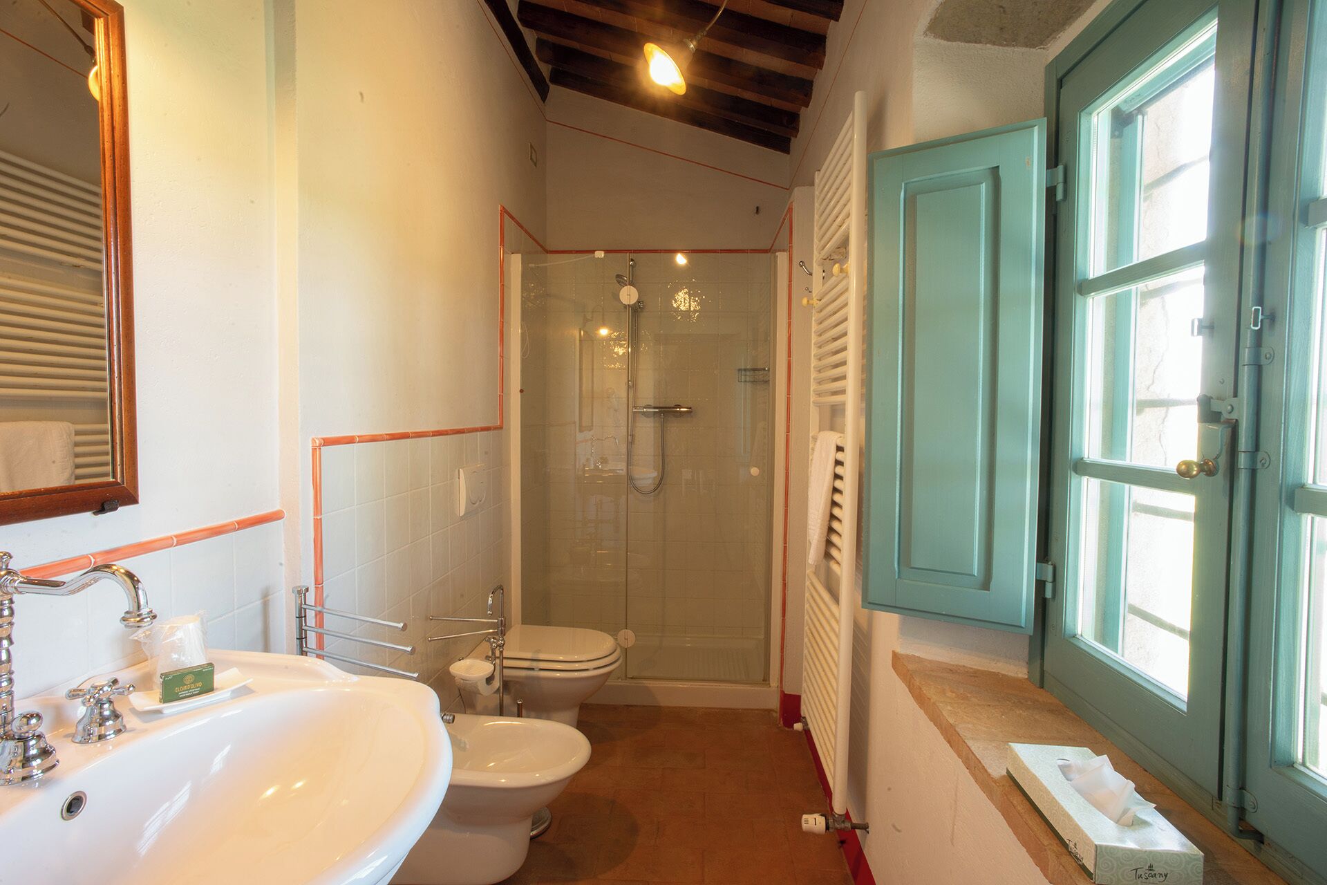 A bathroom with a sink, toilet, bidet, and shower.