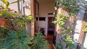 A narrow pathway leading to a room with a bed and a small table. - B&B Crociferi Catania (Catania)