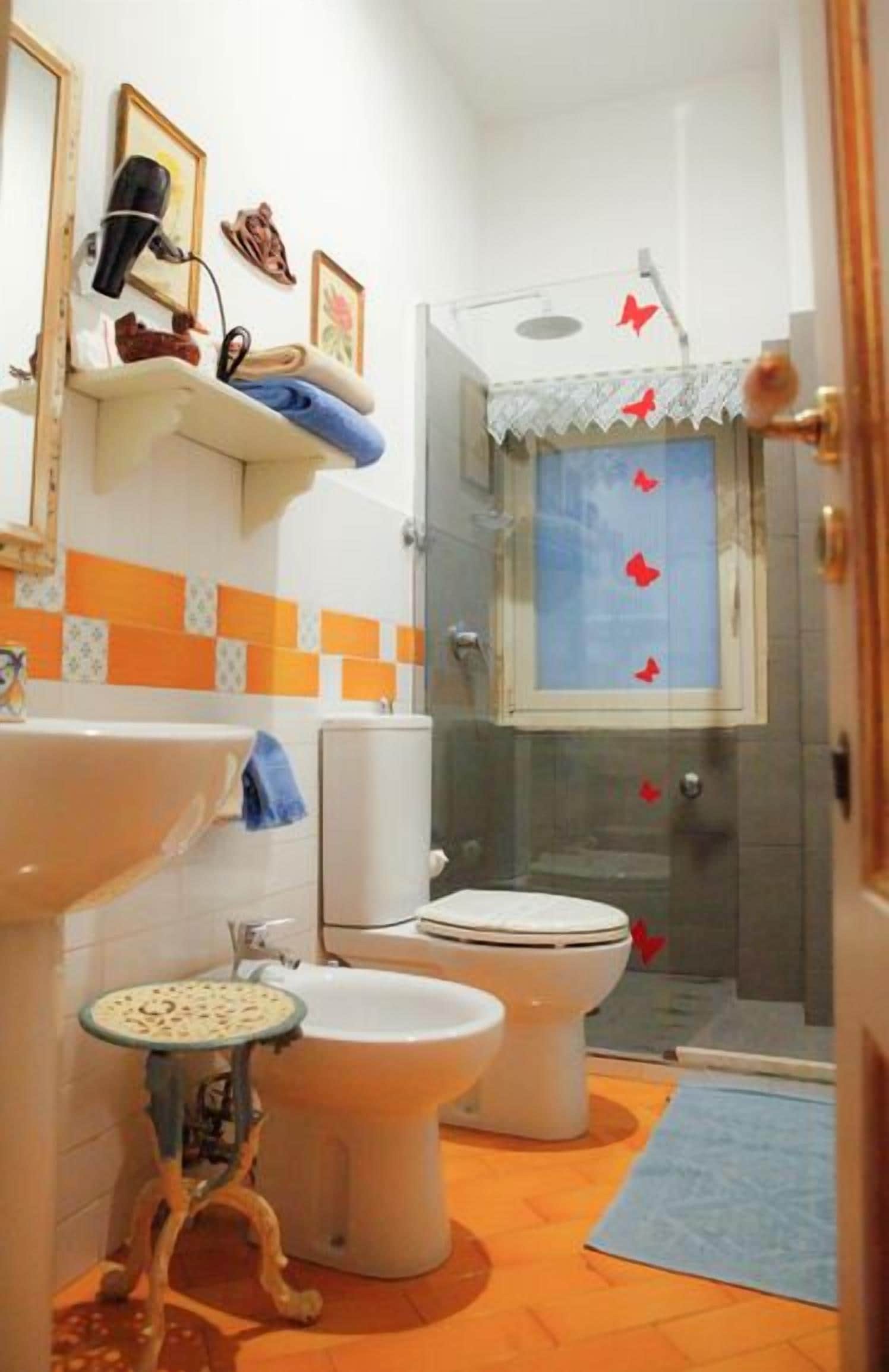 A bathroom with a sink, toilet, and shower area.