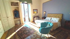 A bedroom with a bed, a chair, a wardrobe, a mirror, and a window. - B&B Crociferi Catania (Catania)