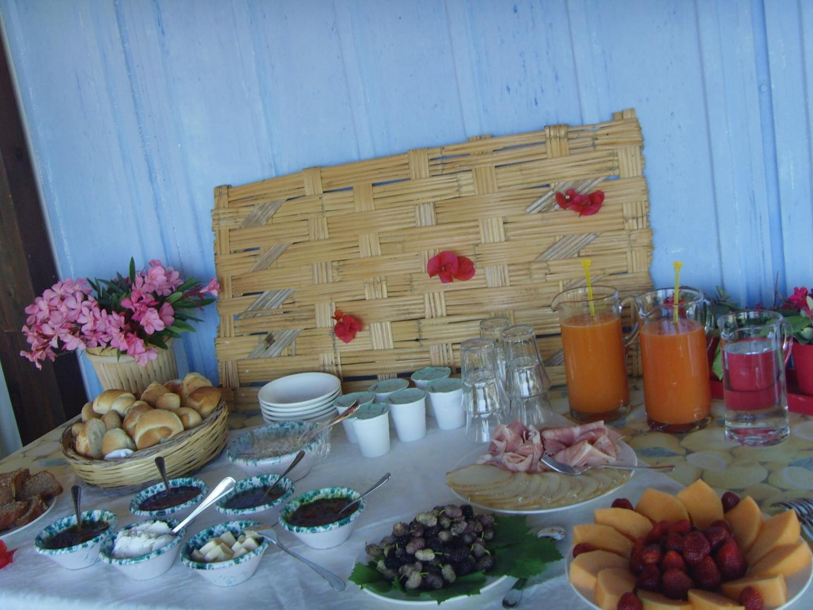 A breakfast buffet with various food items, including bread, fruits, and beverages.