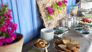 Un bufé de desayuno con pan, bollería y diversos platos.