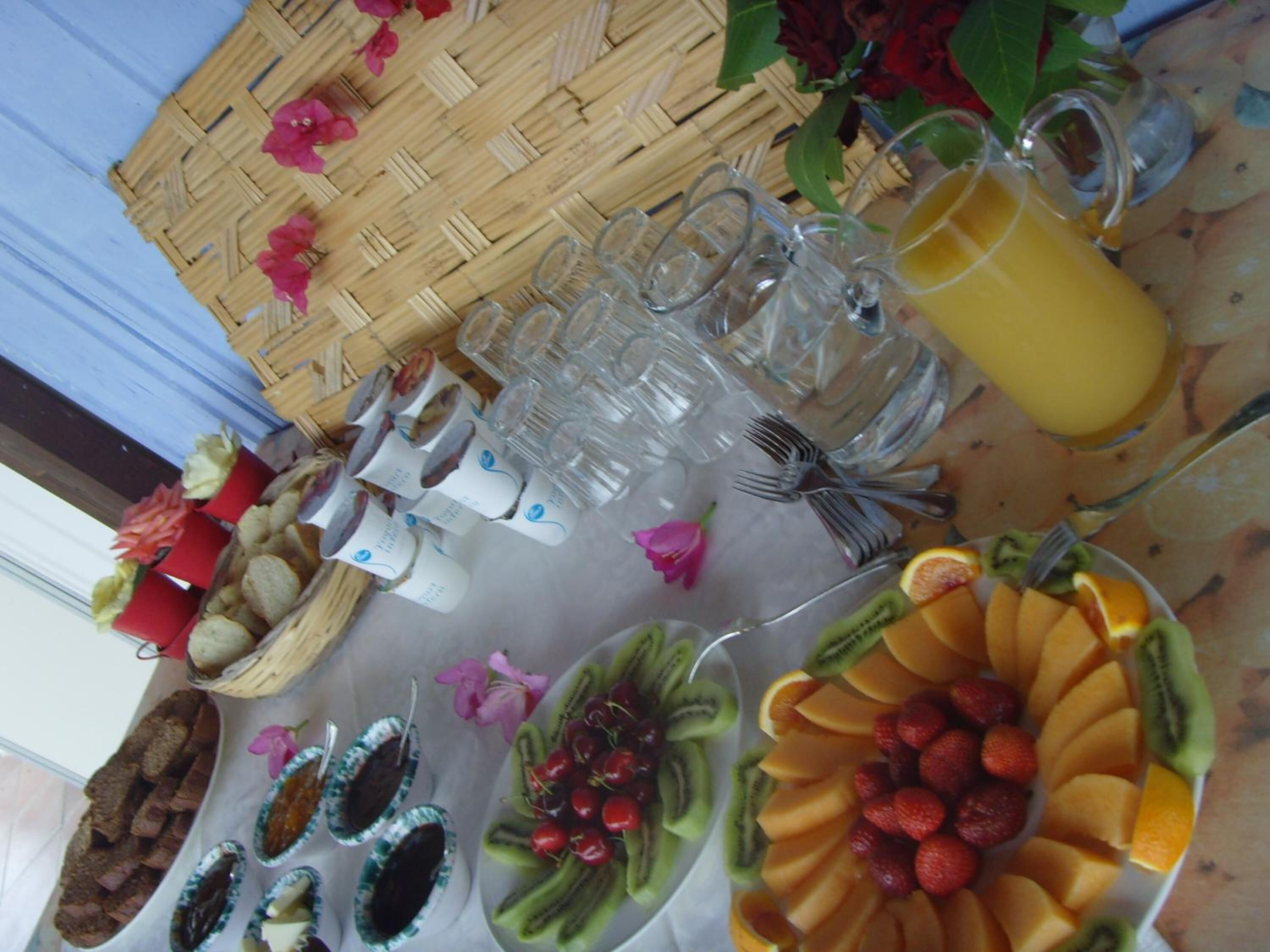 Una mesa con diferentes alimentos, como frutas, pan y una bebida.