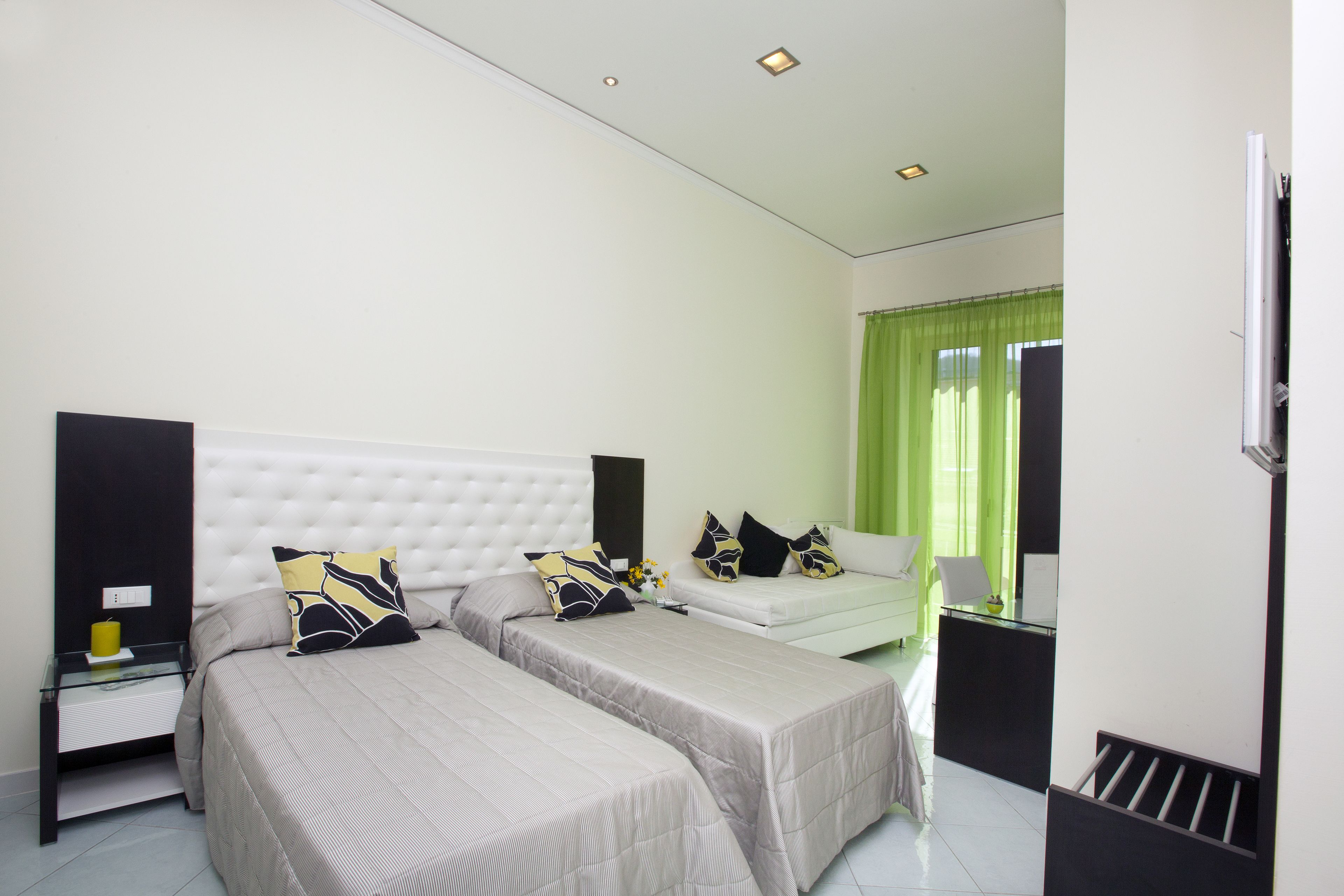 A bedroom with two beds, a desk, and a chair.