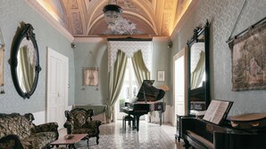 Un salón imponente con dos pianos, muebles ornamentados y una araña.