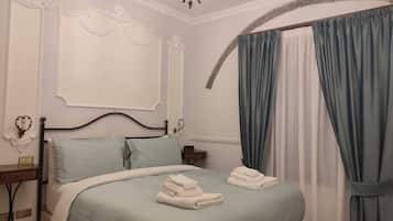 Una camera da letto con un letto, un comodino, un lampadario e tende.