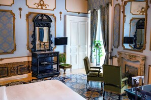 A room with a bed, a fireplace, a mirror, and a chair. - Carafa di Maddaloni B&B di Charme (Naples)