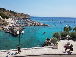 A coastal town with a marina, rocky shoreline, and a paved promenade. - Hotel Degli Ulivi (Castro)