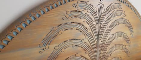 A wooden object with intricate carvings and a scalloped edge.