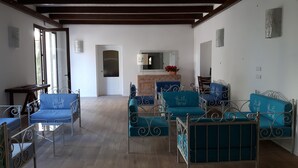 Un amplio espacio habitable con sillones tapizados en azul y un armario de madera.