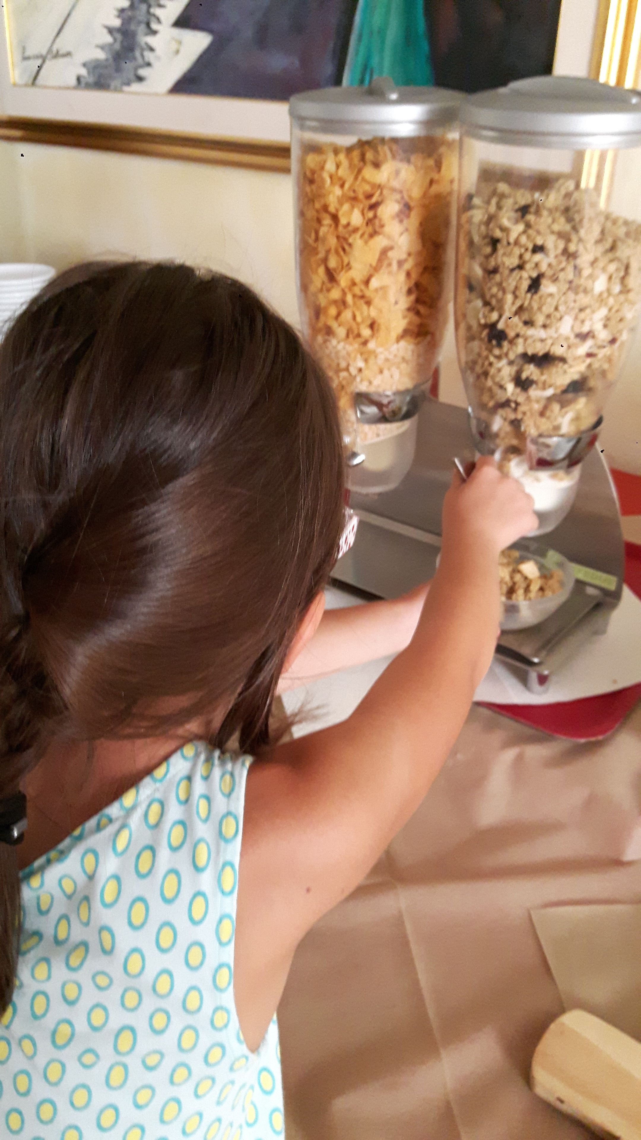 A child reaching for a container of cereal.