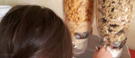 A child reaching for a container of cereal.