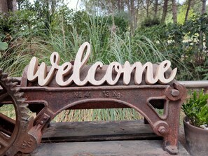 A rustic metal bench with a 'welcome' sign. - Antico Podere Il Bugnolo (Poggibonsi)