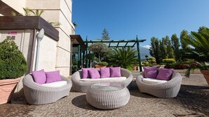 An outdoor seating area with wicker furniture and potted plants. - Hotel Liolá (Castrocielo)