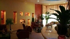 A lobby with a reception desk, seating area, and decorative wall panels. - Marchesina Resort (Teggiano)