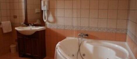 Une salle de bain avec une baignoire, un lavabo et un miroir.