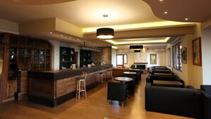 Un área de bar moderna con mostrador de madera, taburetes y asientos.