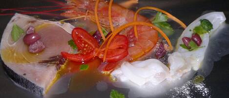A seafood dish with shrimp, fish, and garnishes.