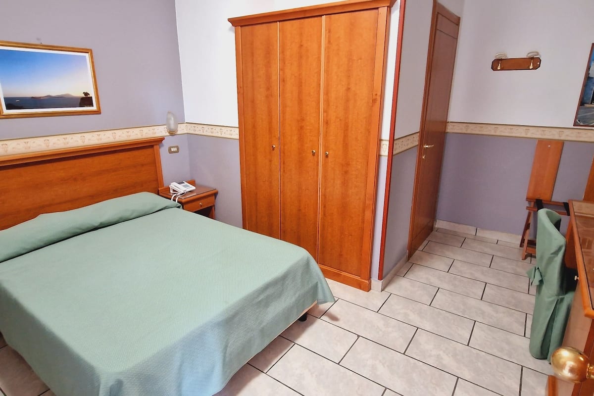 Eenvoudige tweepersoonskamer, voor 1 persoon | Een kluis op de kamer, een bureau, een strijkplank/strijkijzer