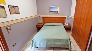 A hotel room with a single bed, a nightstand, a bedside table, a wooden wardrobe, and a framed picture on the wall. - Hotel Lento (Melito di Napoli)