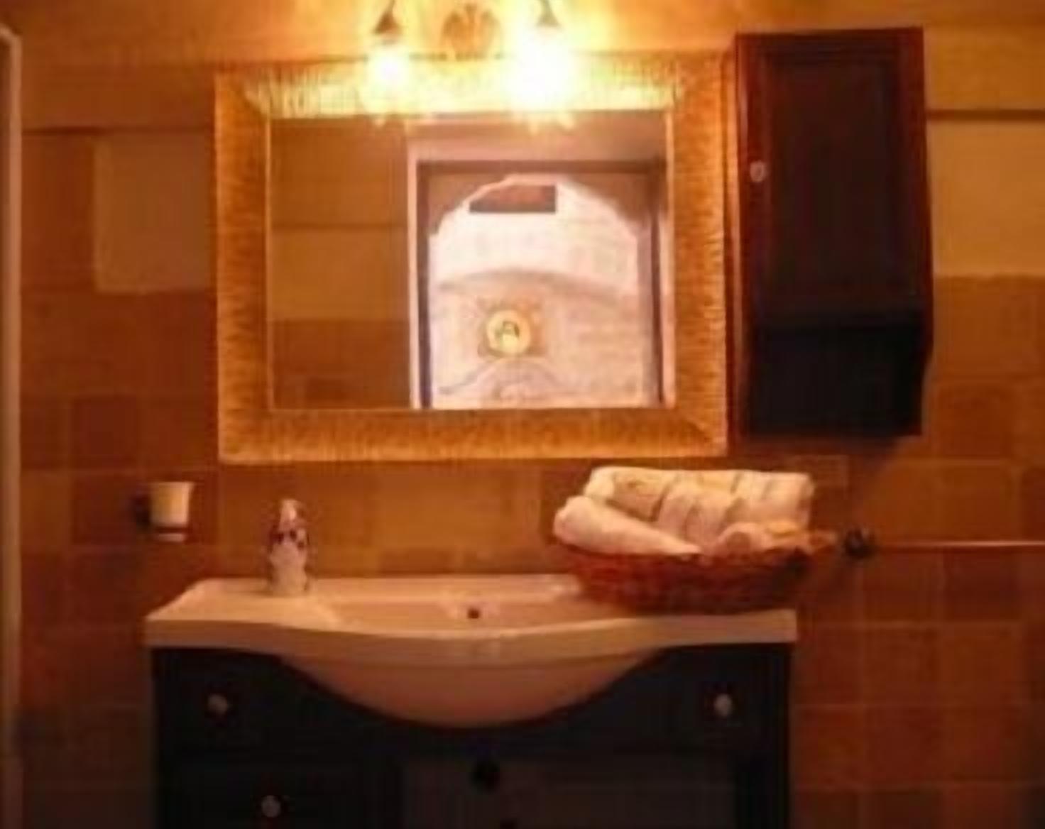 Ein Badezimmer mit Waschbecken, Spiegel und Handtuchhalter.