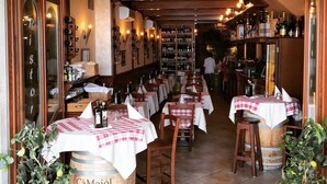A restaurant interior with tables set for dining, a wine rack, and a barrel labeled "Cà Maiol". - Hotel Monte Baldo (Limone sul Garda)