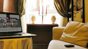 A room with a laptop on a table, a sofa, and a window with curtains. - Bed and Breakfast Rosmini (Rome)