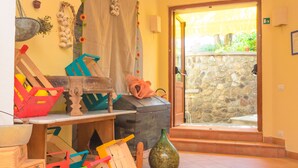 A room with a stone wall, a wooden table, and a large window. - Albergo Villa Giusto (Barano d'Ischia)