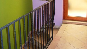 A staircase with a metal railing, a green wall, a wooden door, and a wall-mounted light fixture. - Bed & Breakfast De Nittis - Meridia Collection (Barletta)